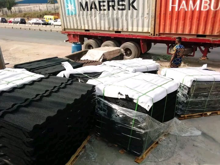 Palletised black and red stone-coated roof tiles offloaded from Maersk container